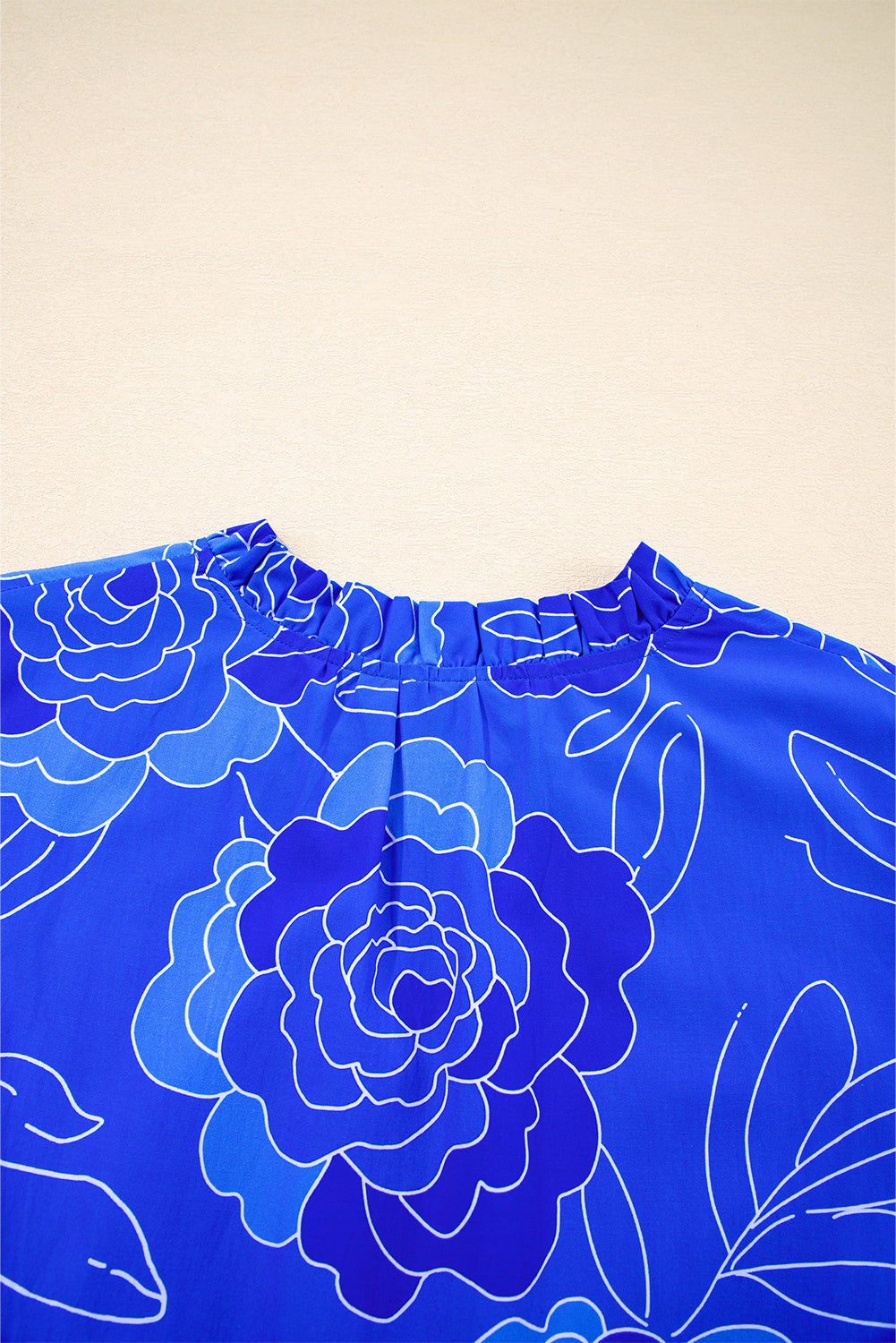 Close-up of the Blue Crush Dress neckline featuring vibrant cobalt floral design and ruffled detail.