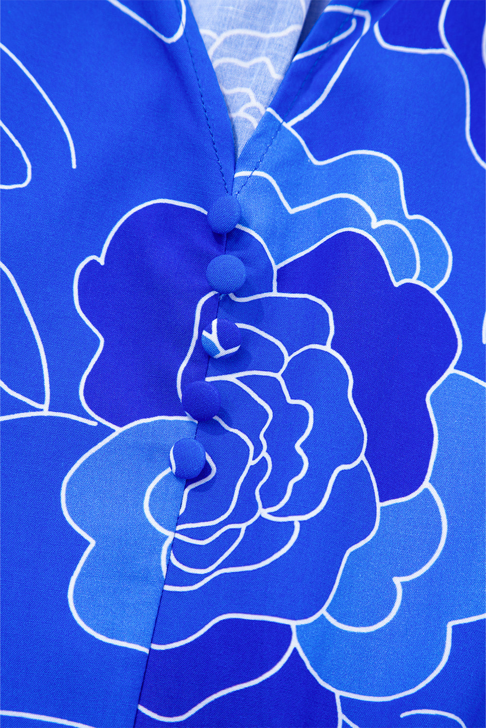 Close-up of the Blue Crush Dress showcasing its vibrant floral pattern and stylish V-neckline with decorative buttons.