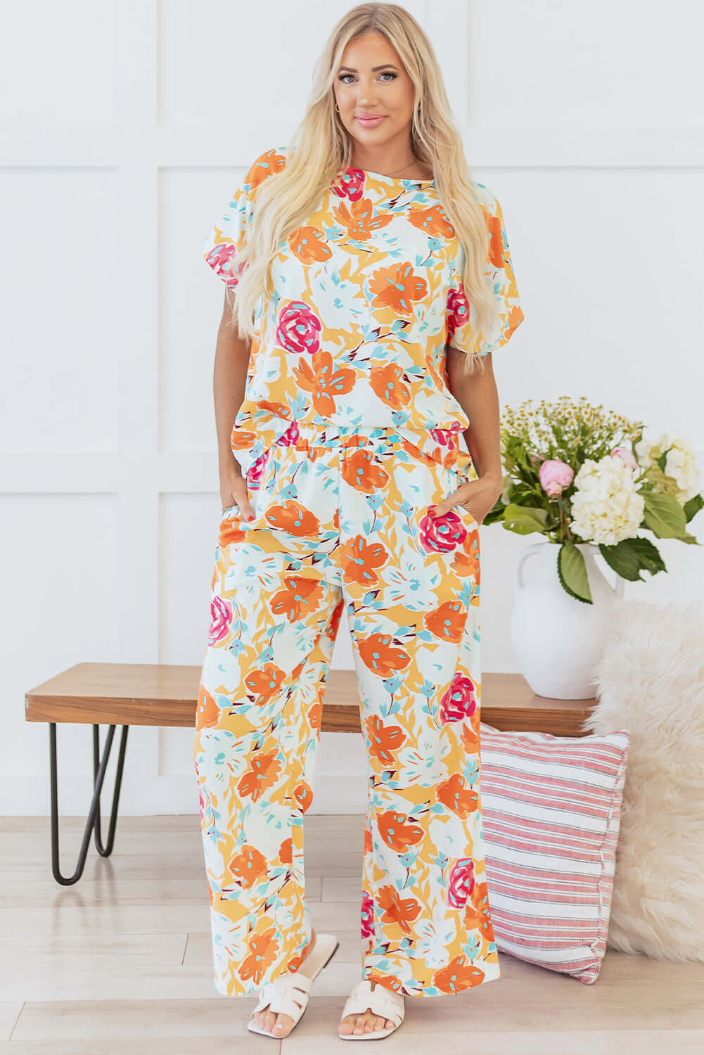 Model wearing the Sunset Stroll Pants Set featuring tangerine floral prints and matching wide-leg pants for a stylish look.