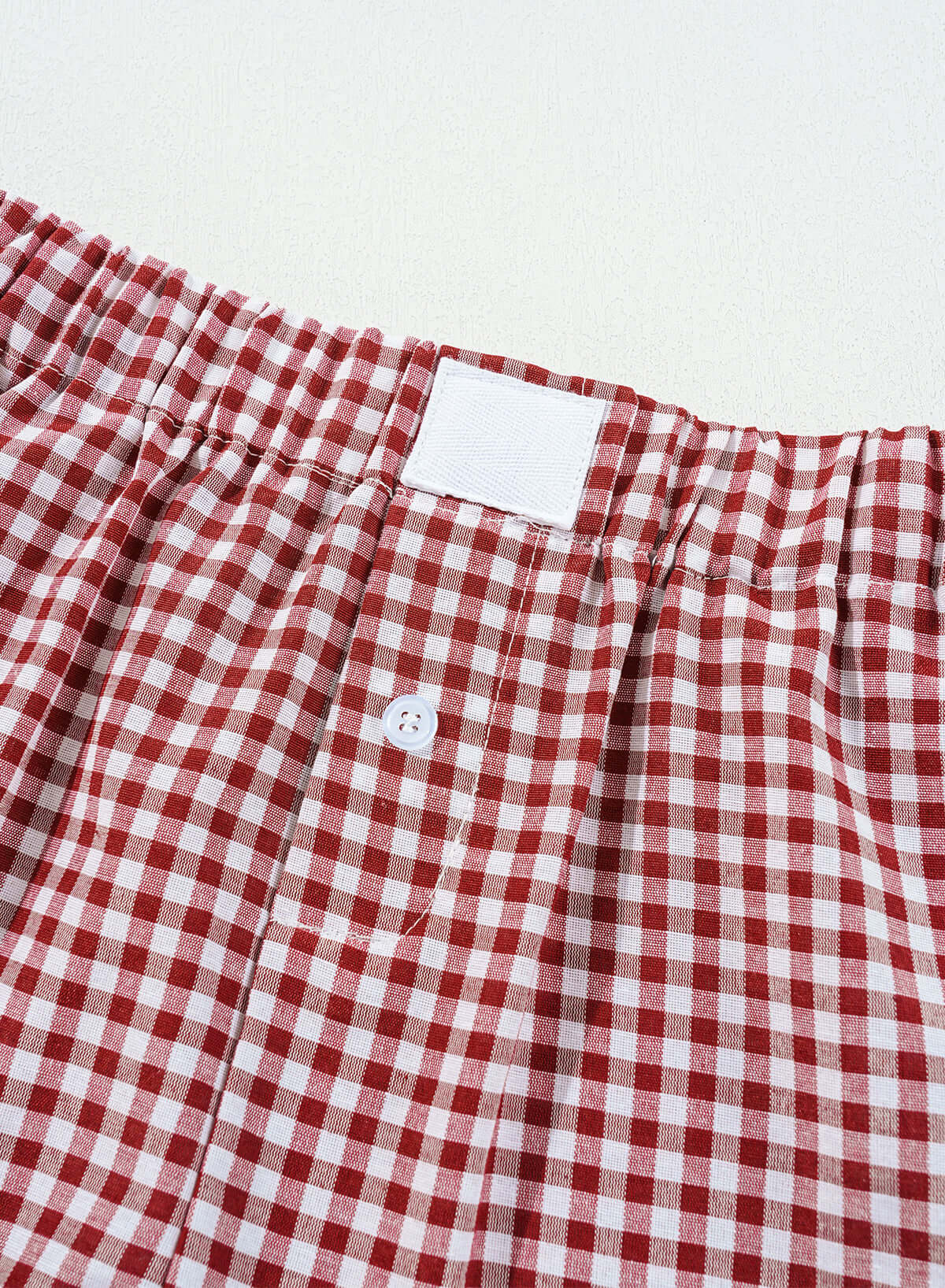 Red gingham picnic perfect shorts with elastic waistband and button detail for comfort and style.