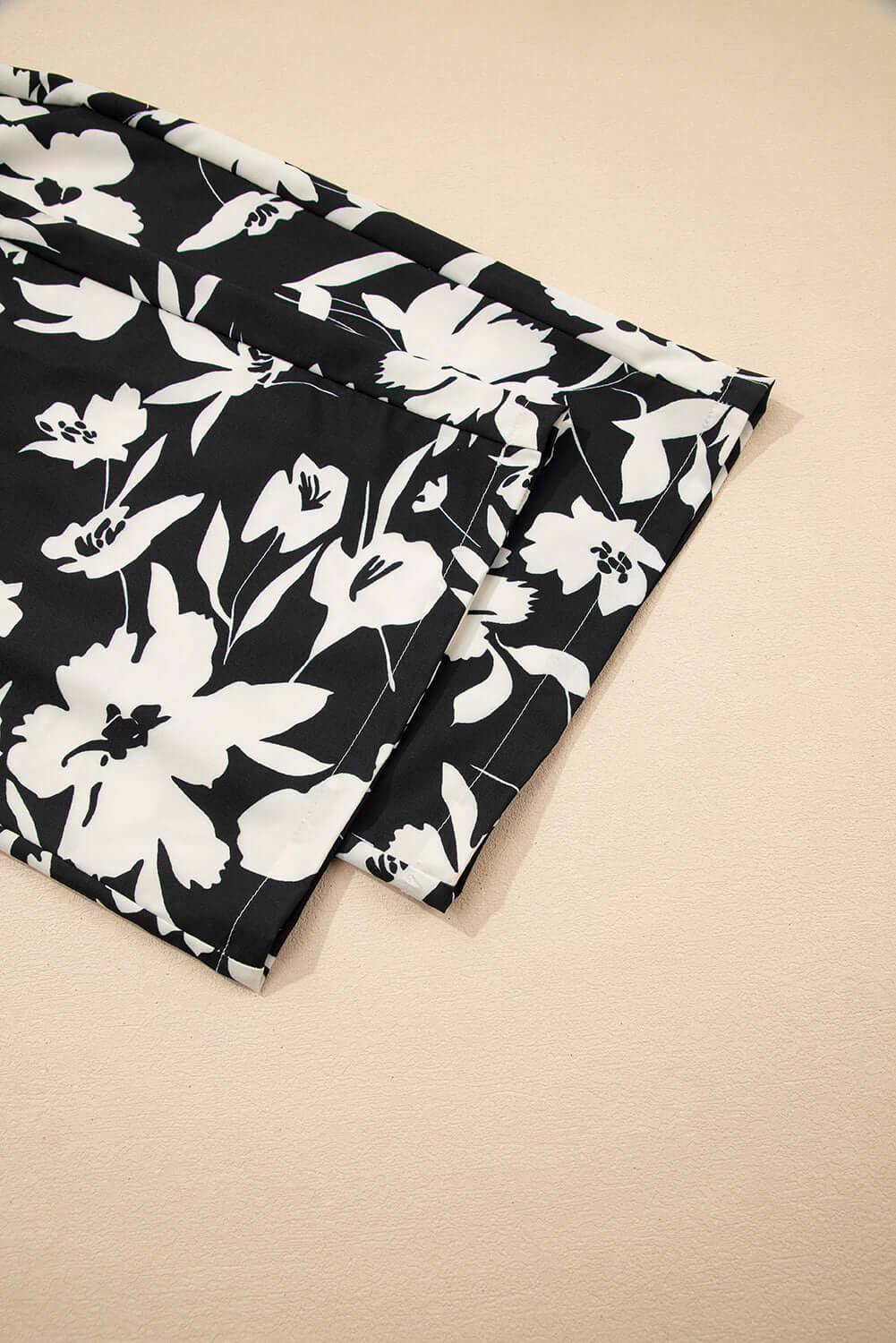 Close-up of EVENING OUT WIDE LEG PANTS in black floral print, showcasing fabric detail and design.