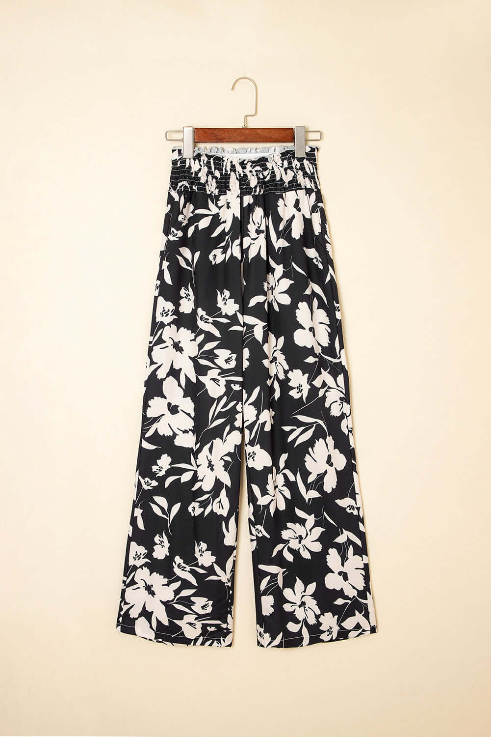 Evening Out Wide Leg Pants in black floral print, featuring a smocked high waist and flowy wide-leg silhouette.