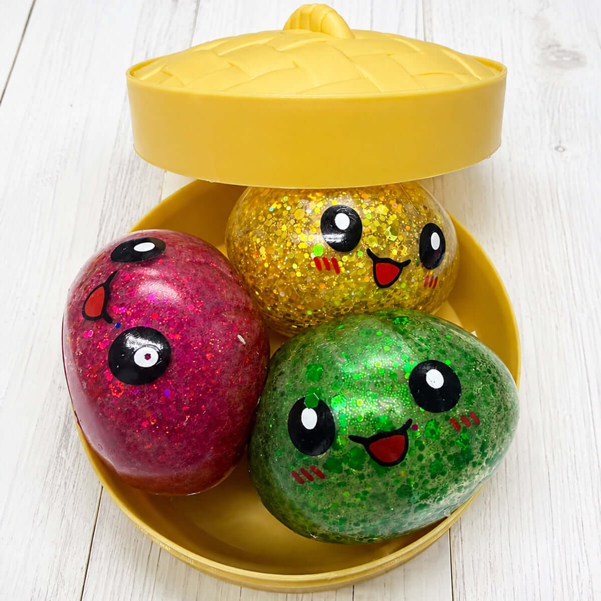 GLITTER ORBEEZ DUMPLING TRIO in a yellow steamer with colorful glitter dumplings, showcasing vibrant colors and playful expressions.