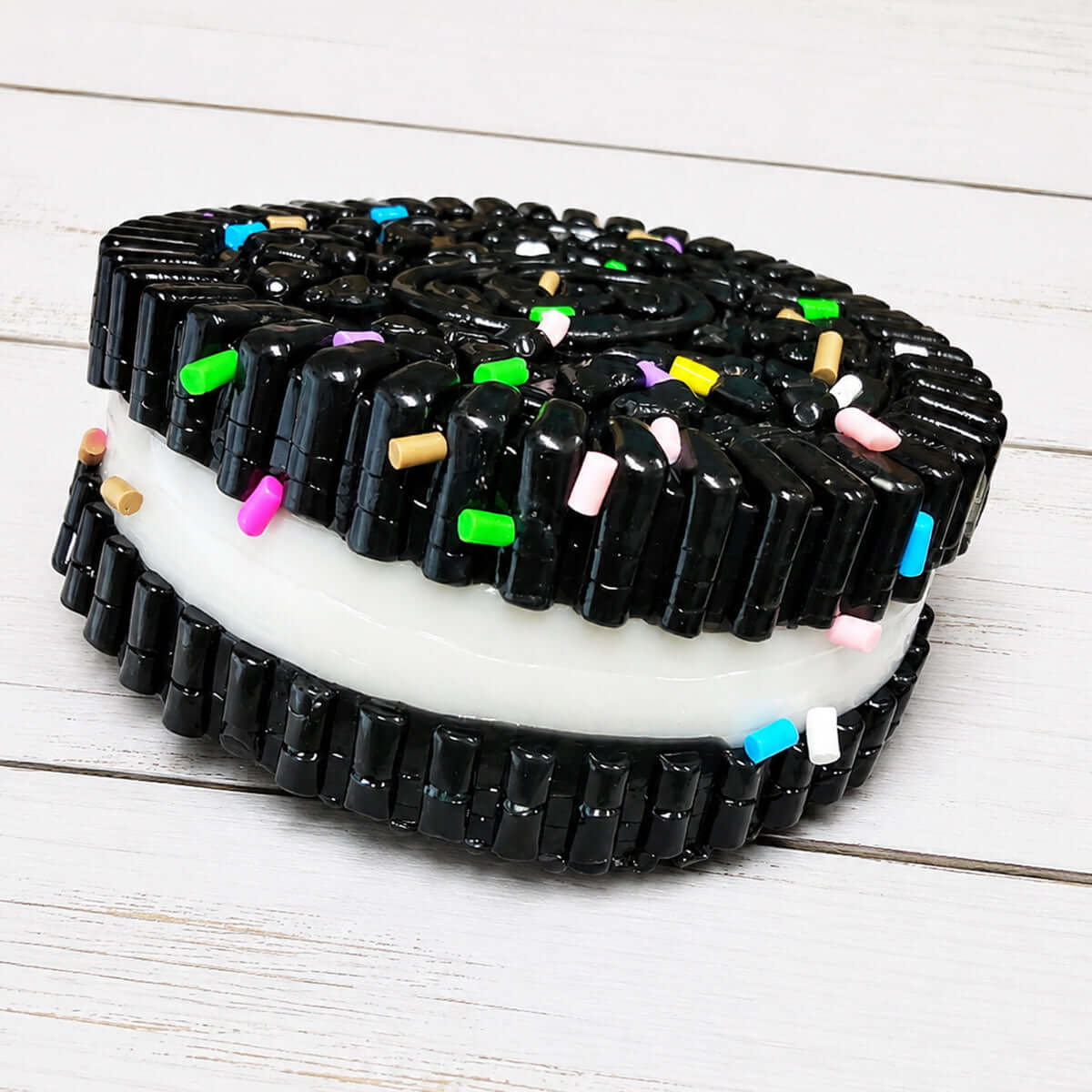 SANDWICH COOKIE SQUISHY - adorable black and white squishy toy with colorful sprinkles, perfect for stress relief or sensory play.