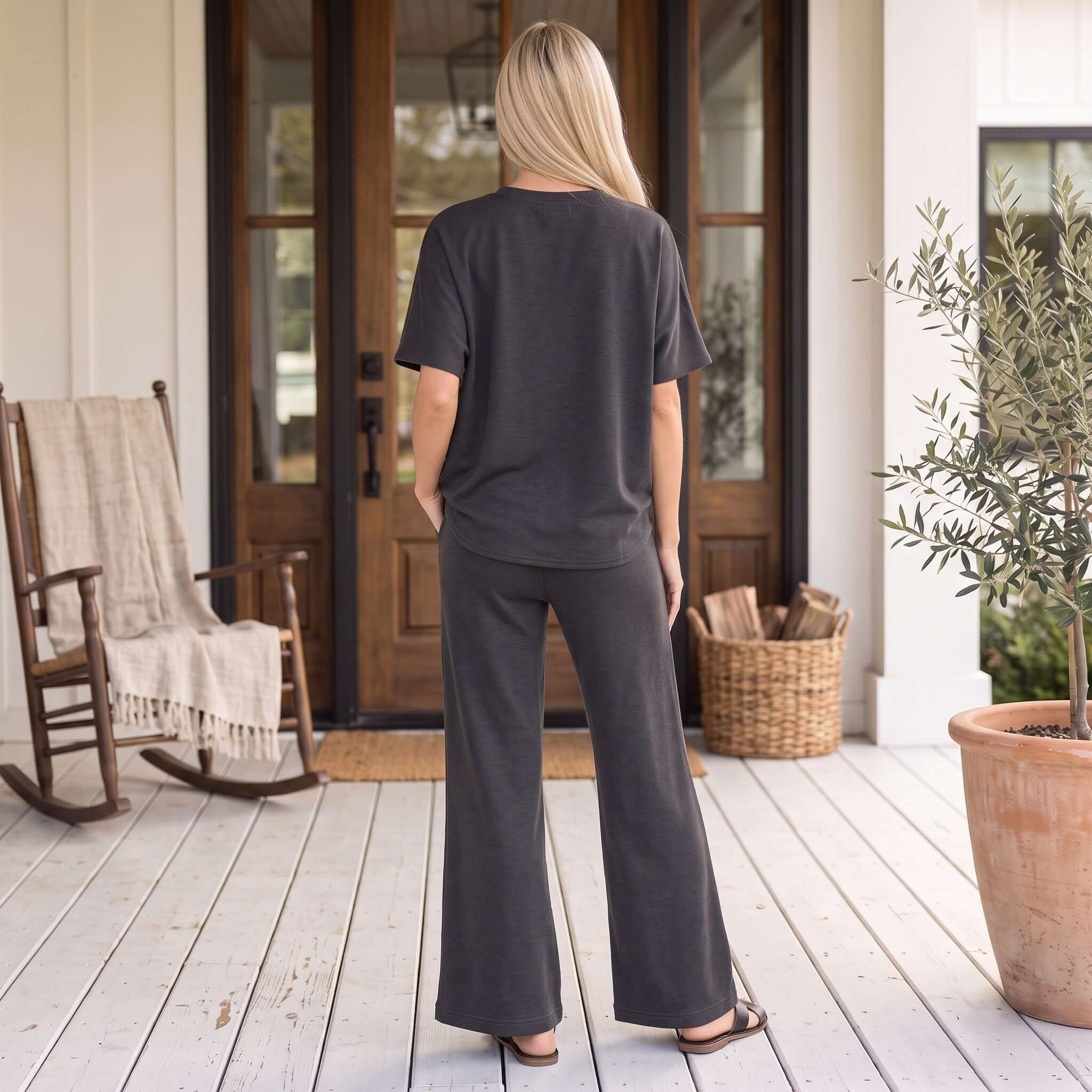 Model wearing MIDNIGHT REIGN PANTS SET (blk) from behind, showcasing the relaxed fit and bell-bottom style.