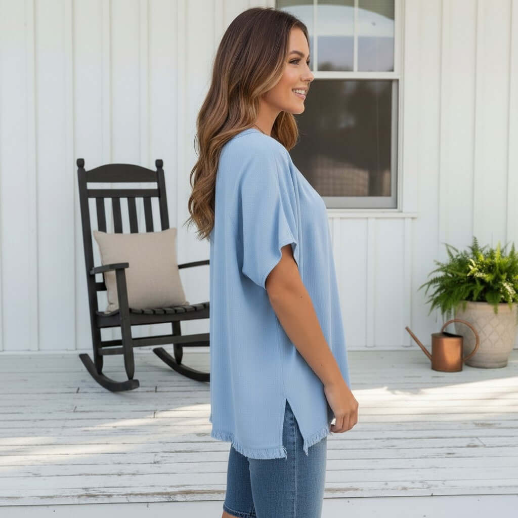 Model wearing the COASTAL DAYDREAMS TOP - GIgio in light blue, showcasing its flowy fit and relaxed style.
