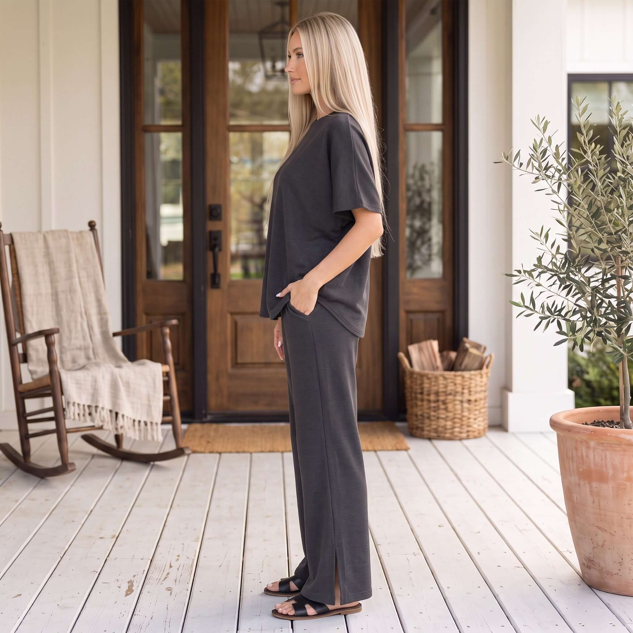 Model wearing the MIDNIGHT REIGN PANTS SET (blk) in a relaxed fit, showcasing sleek black fabric and bell-bottom design.