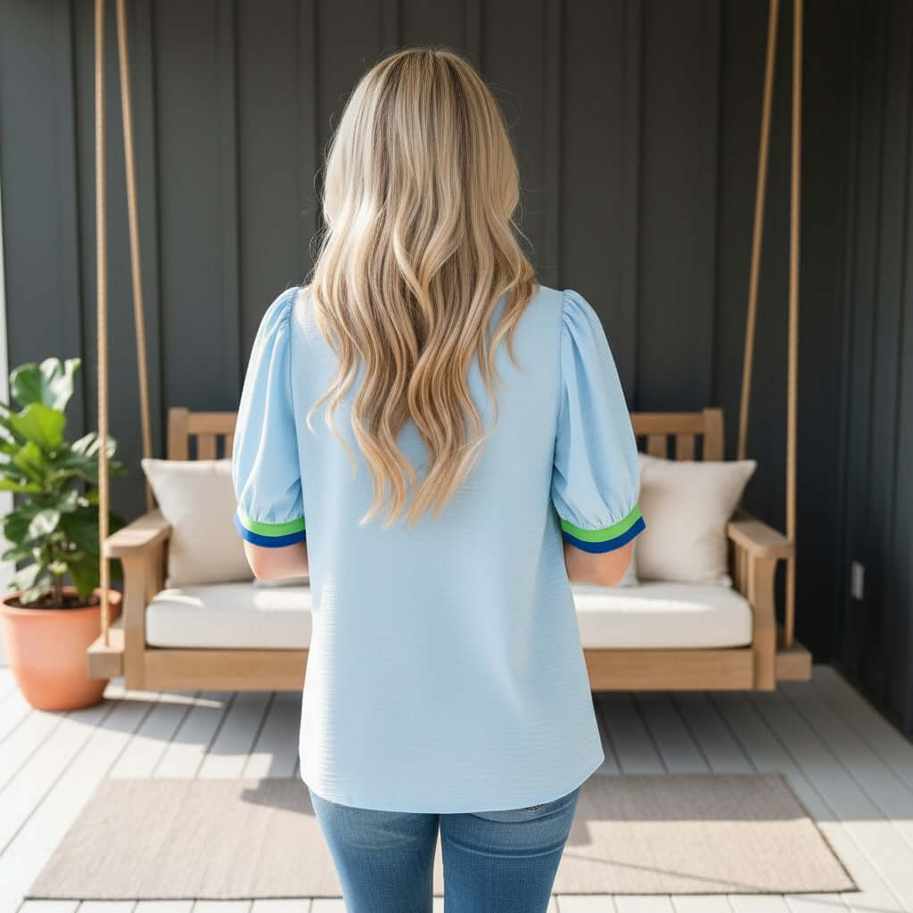BREATHE EASY TOP - Jodifl worn by a woman from behind, featuring a soft baby blue color and stylish green and blue accents.