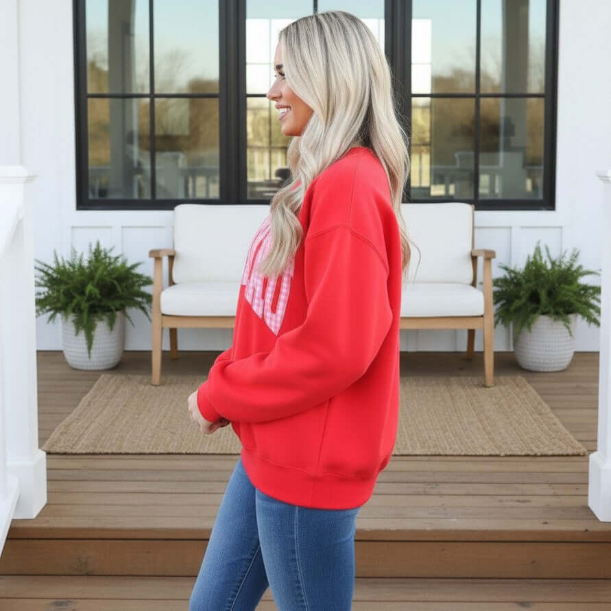 LULU MAC RED W/PINK GINGHAM CREWNECK worn by a woman, featuring vibrant red fabric and pink gingham design.