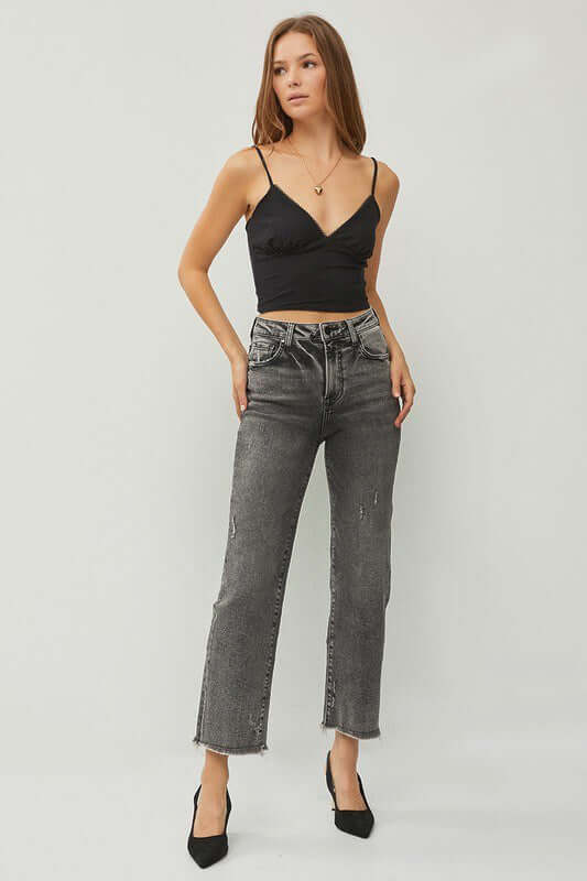 Model wearing RISEN Veronica Jeans in acid wash black, showcasing high rise straight leg and trendy frayed hem.