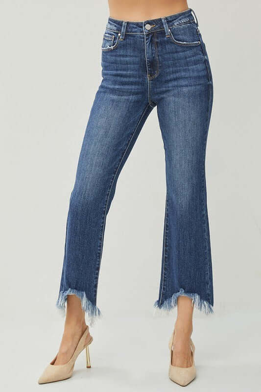 Risen Phoebe Jeans in dark wash with shark bite hem, paired with stylish heels for a trendy look.