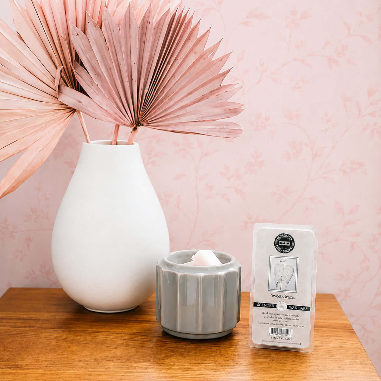 SWEET GRACE WAX MELTS displayed next to a decorative vase and candle holder on a wooden table.