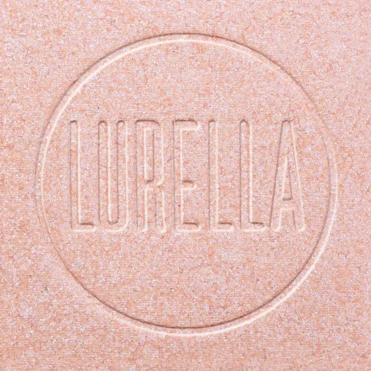 Lurella highlighter compact featuring an embossed logo on a soft pink background.