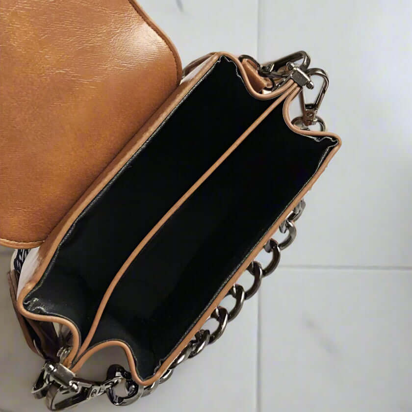 Inside view of Urban Sweetheart Crossbody Bag showing black lining and maple brown faux leather exterior.