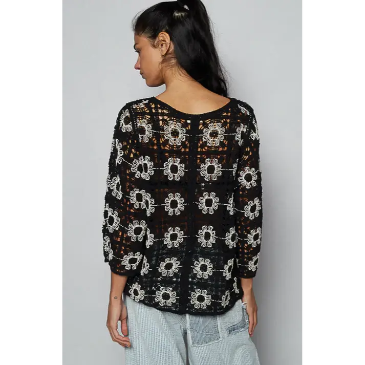 Back view of the Black Dahlia Cardigan featuring open crochet design and floral embroidery.
