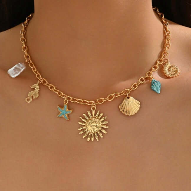 Sunseeker Charm Necklace featuring golden sun, seahorse, starfish, seashells, and iridescent pearl, perfect for coastal vibes.