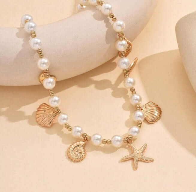 Seaside Glam Charm Necklace with pearl beads and seashell charms, featuring a starfish centerpiece.