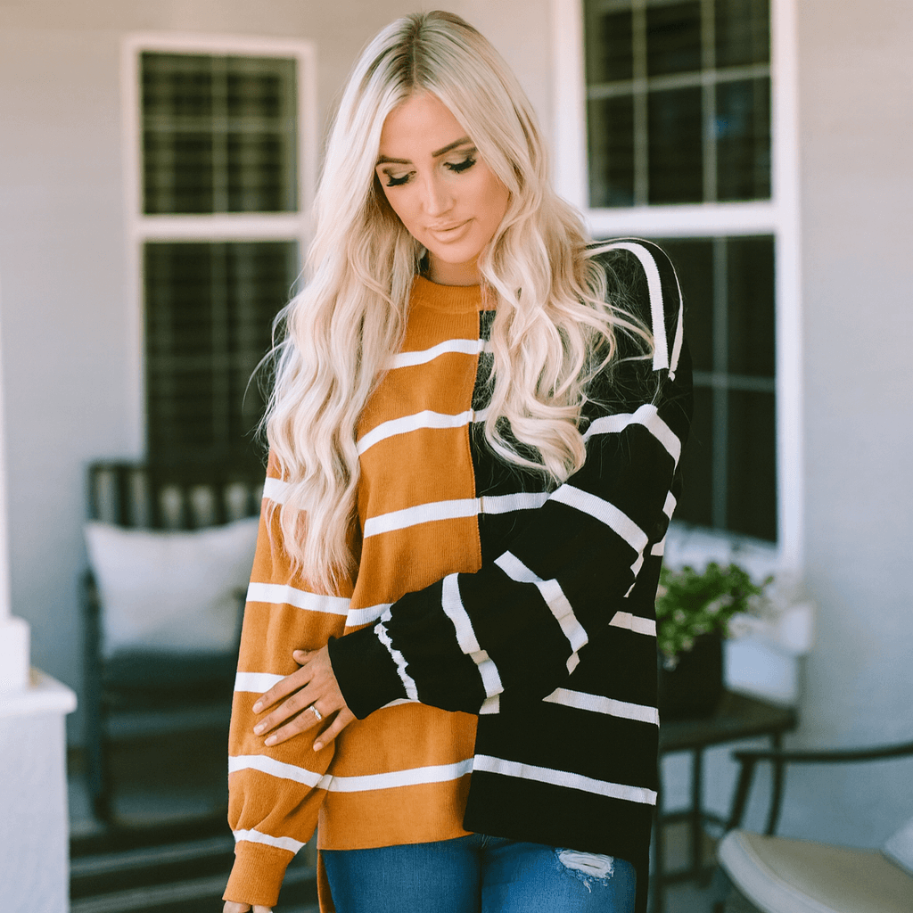 Woman wearing HARVEST SPICE TOP, a striped oversized top with dropped shoulders, showcasing cozy fall fashion.