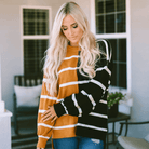 Woman wearing HARVEST SPICE TOP, a striped oversized top with dropped shoulders, showcasing cozy fall fashion.