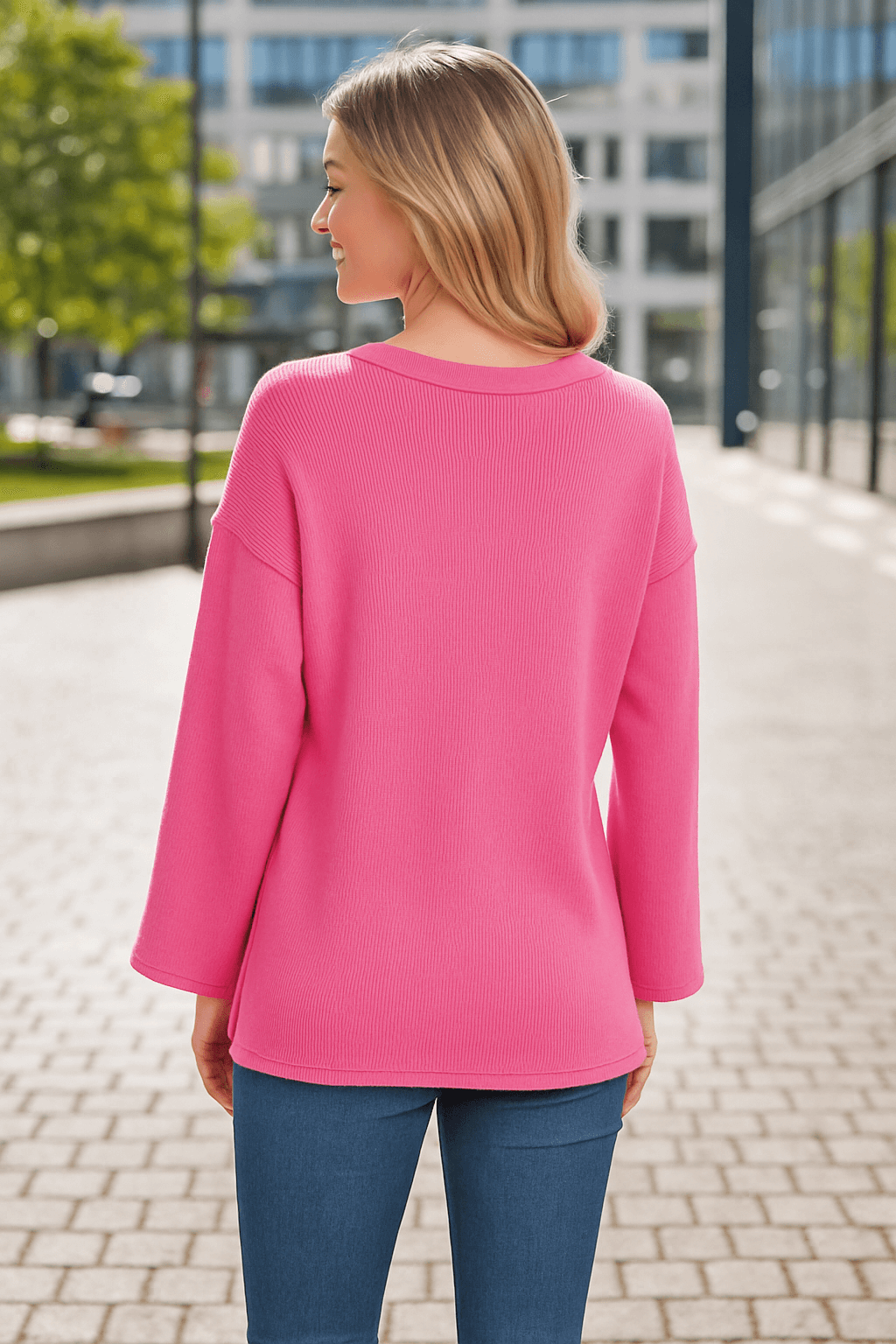 Back view of a woman wearing the CASUAL CHARM TOP - Zenana in pink, showcasing its relaxed fit and flowy bell sleeves.