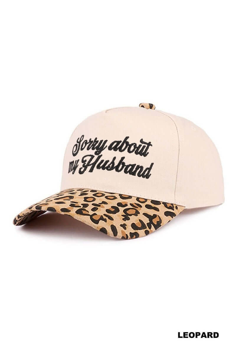 SORRY ABOUT MY HUSBAND HAT (6 colors) in leopard print, featuring embroidered script on a cream base.