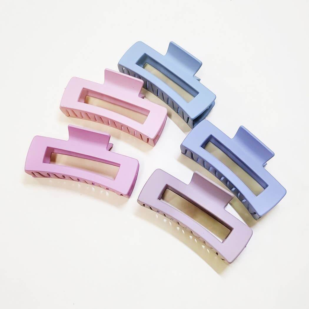 Large matte finish claw clips in pastel pink and blue colors for stylish hair updos.
