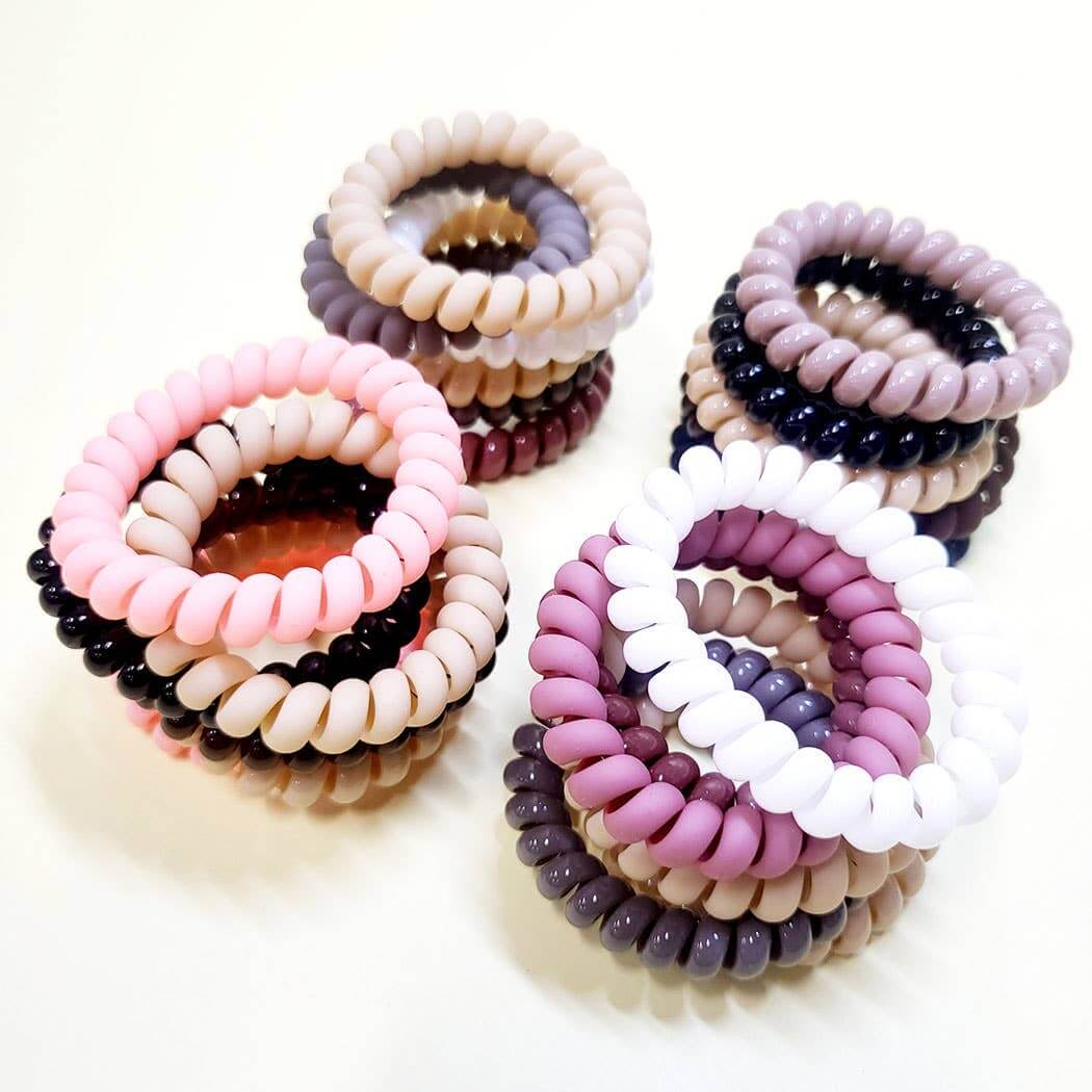 6-piece Twist & Tell Hair Tie Set featuring assorted neutral coil bands in pink, purple, and black.