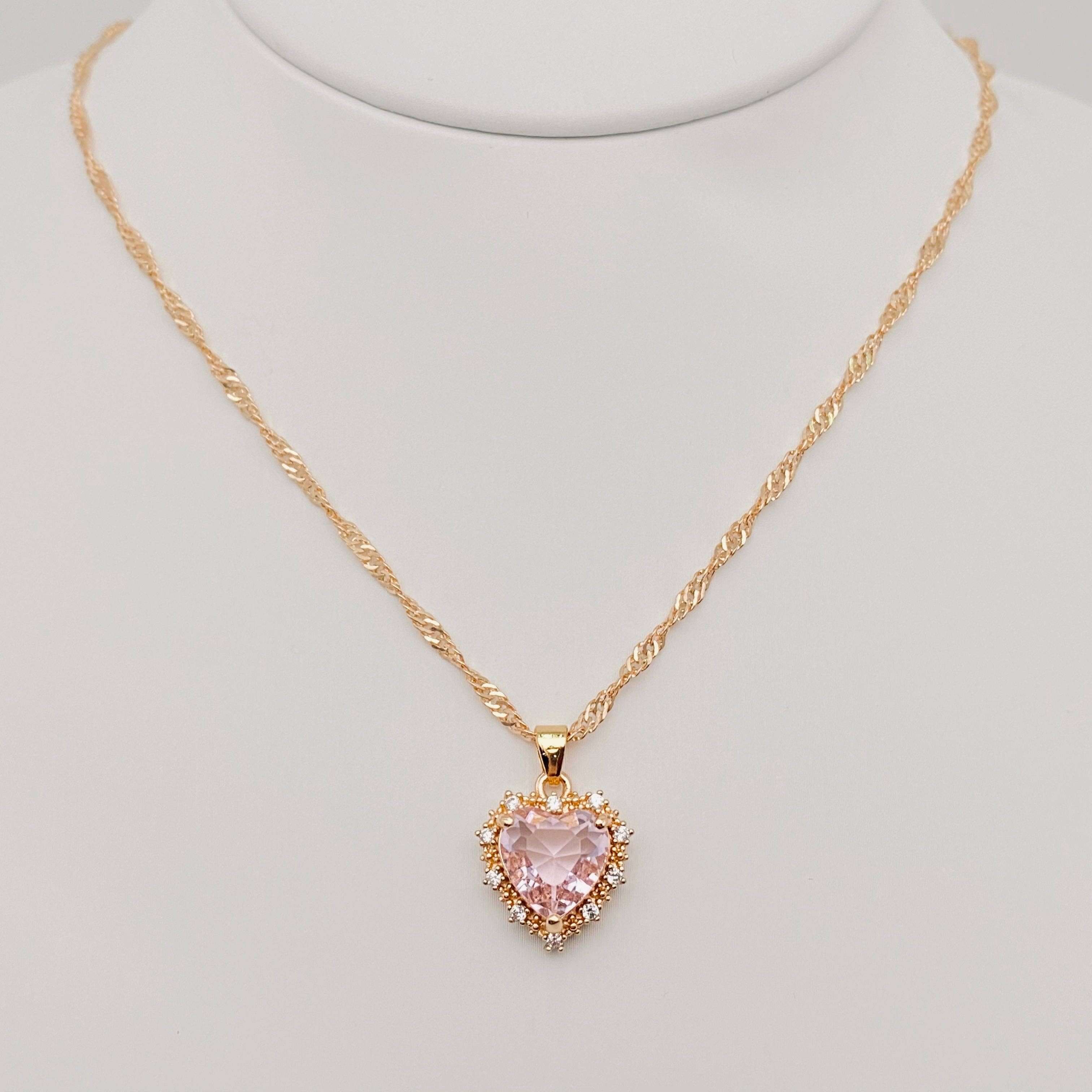 Heart-shaped Pendant Necklace Inlaid Cubic Zirconium featuring a pink cubic zirconia surrounded by gold accents.