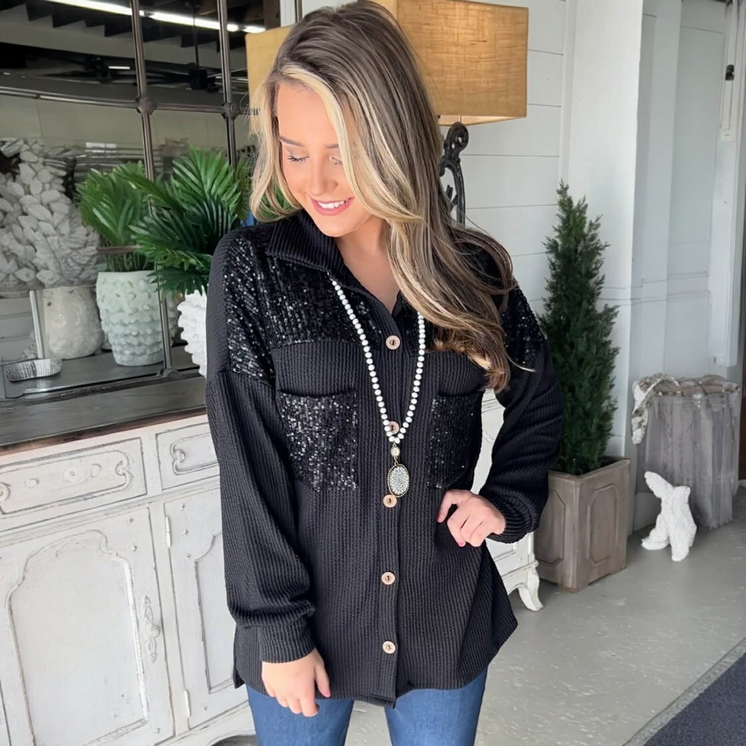 Stylish woman wearing CITY LIGHTS TOP, a black corded shacket with sequin patch chest pockets, perfect for chic everyday looks.
