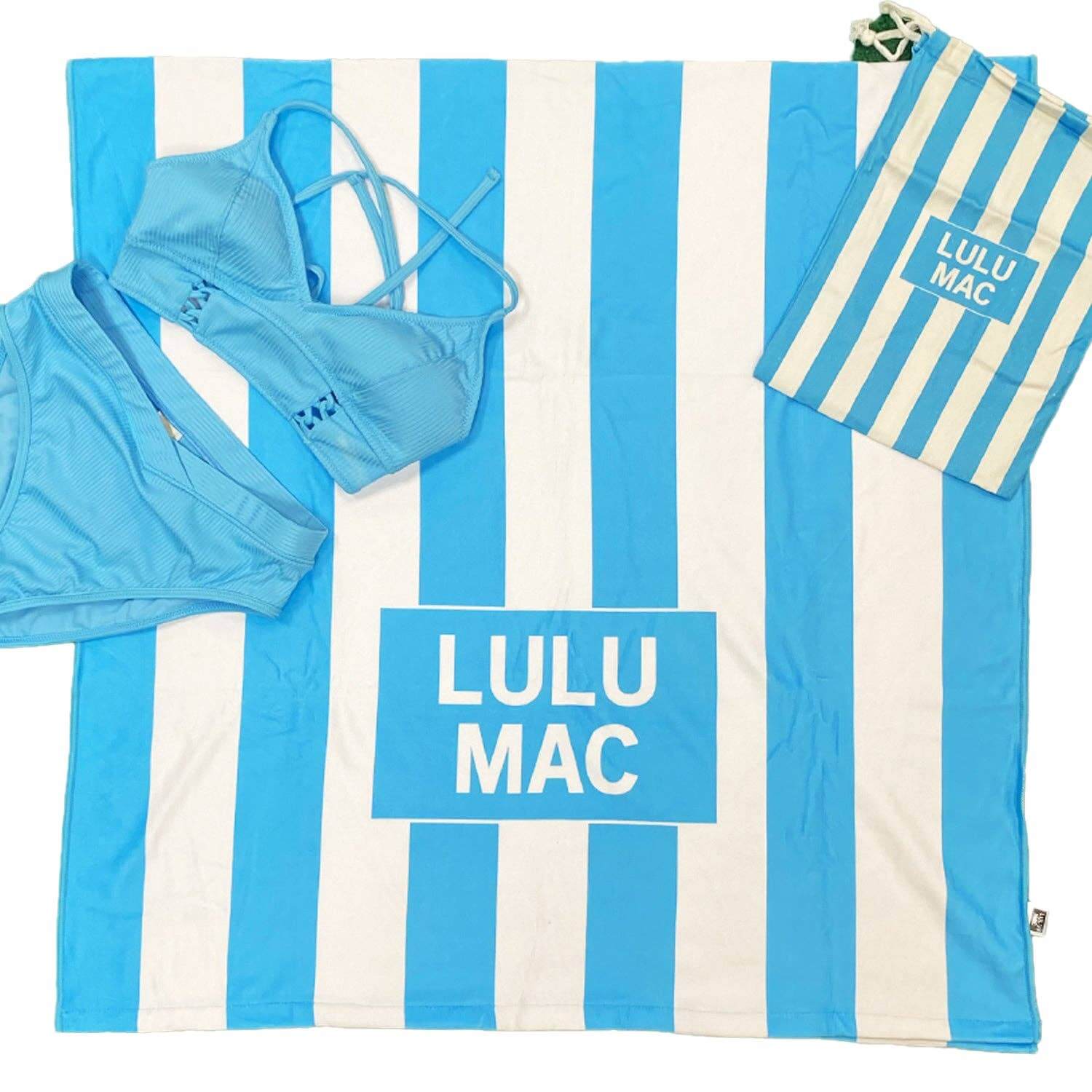 LULU MAC DARBY BEACH TOWEL (sky blue) laid out with blue bikini and striped burlap bag, ideal for summer outings.