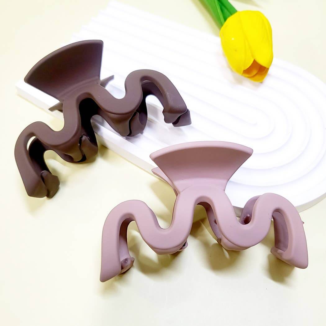 Curve Appeal Hair Clips in matte wavy design, showcasing two colors on a stylish surface with a flower.