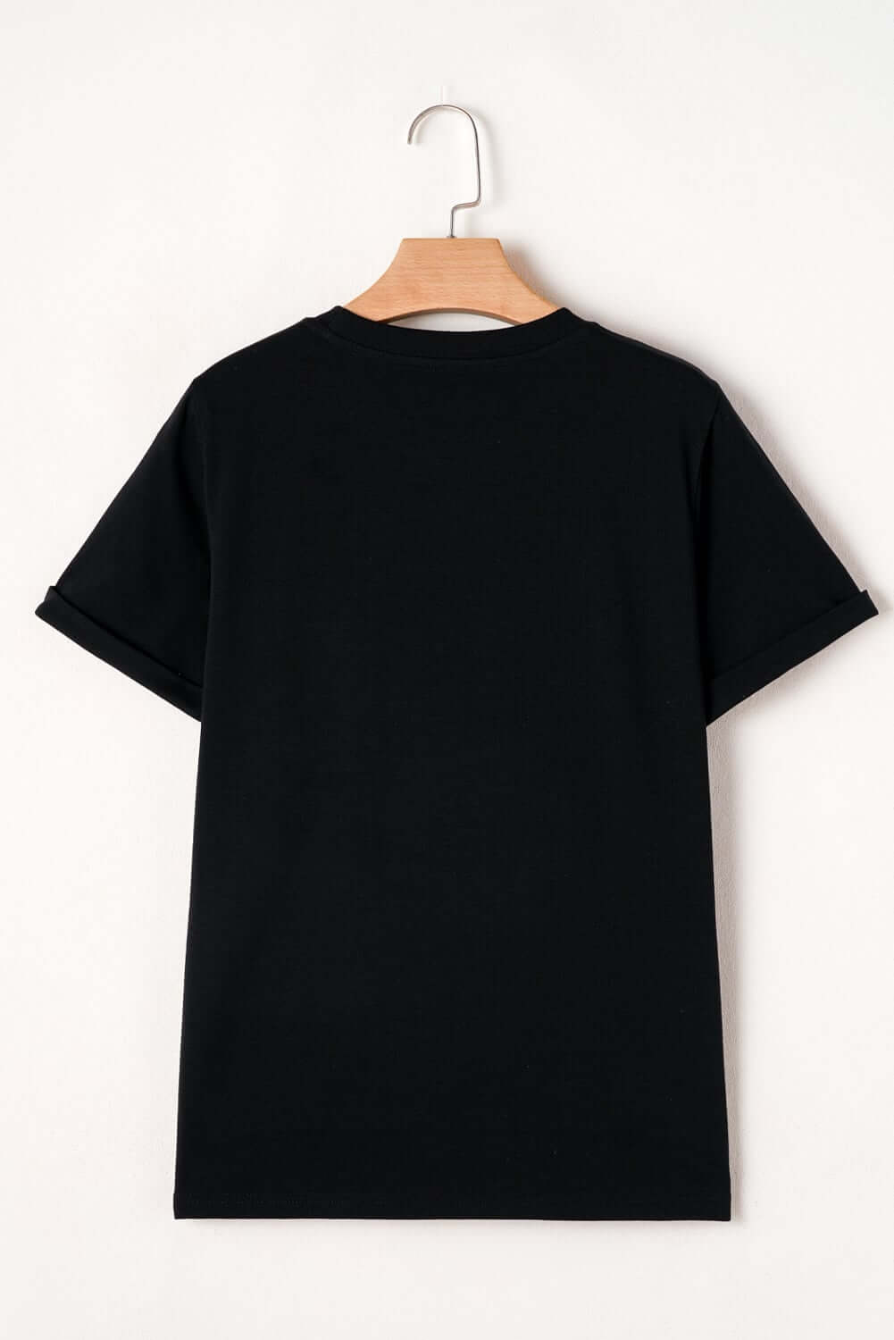 Black t-shirt hanging, showcasing the back view, perfect for casual styling and versatility.