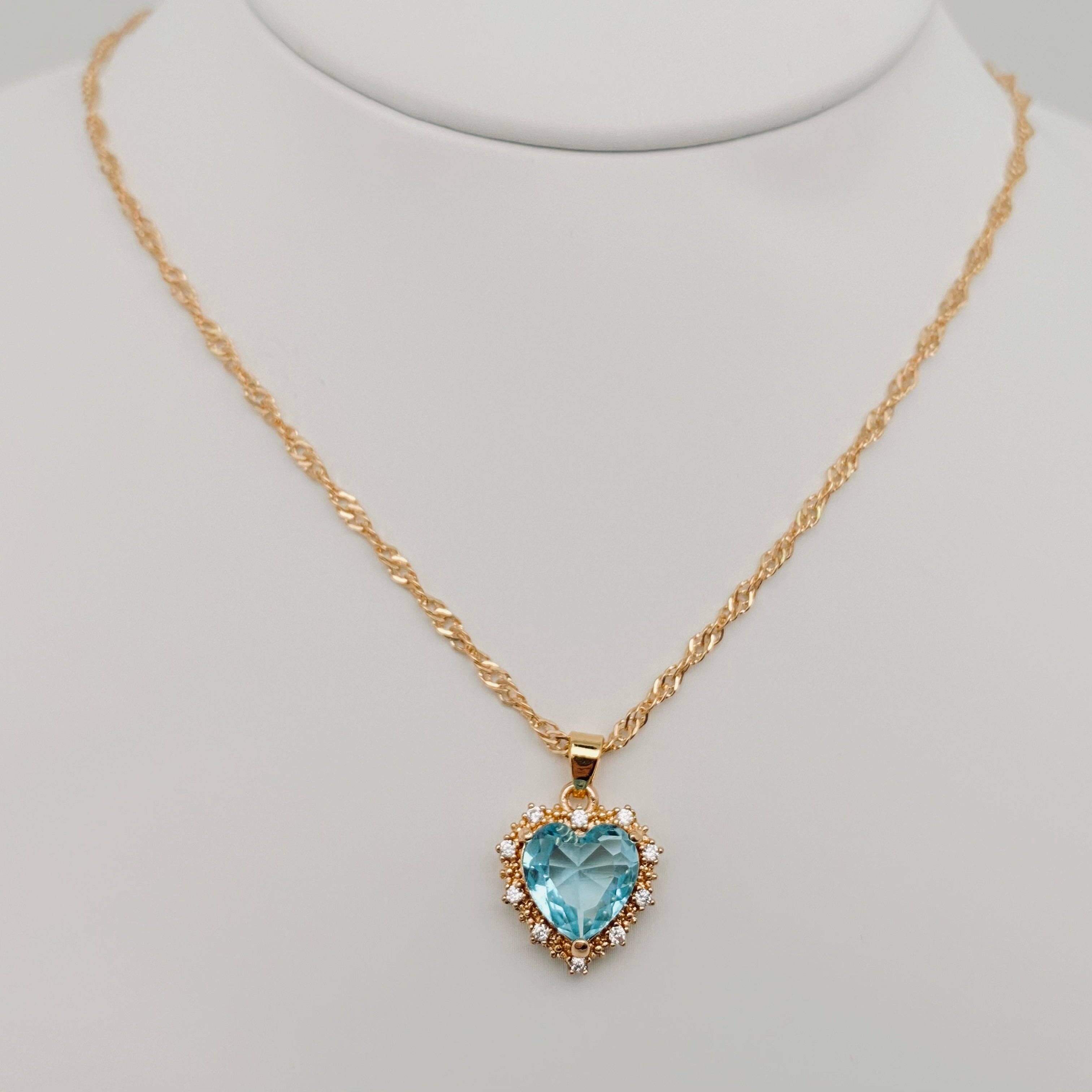 Heart-shaped Pendant Necklace Inlaid Cubic Zirconium featuring a blue cubic zirconia center on a gold chain.