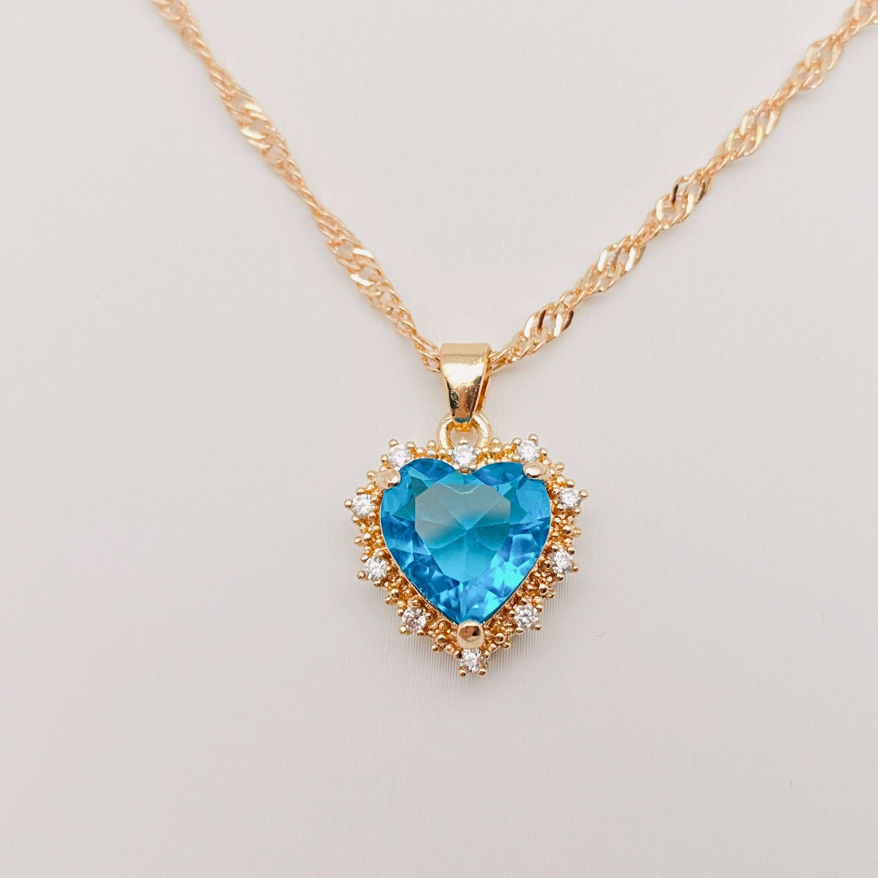 Heart-shaped Pendant Necklace Inlaid Cubic Zirconium with a blue cubic zirconia centerpiece and gold chain.