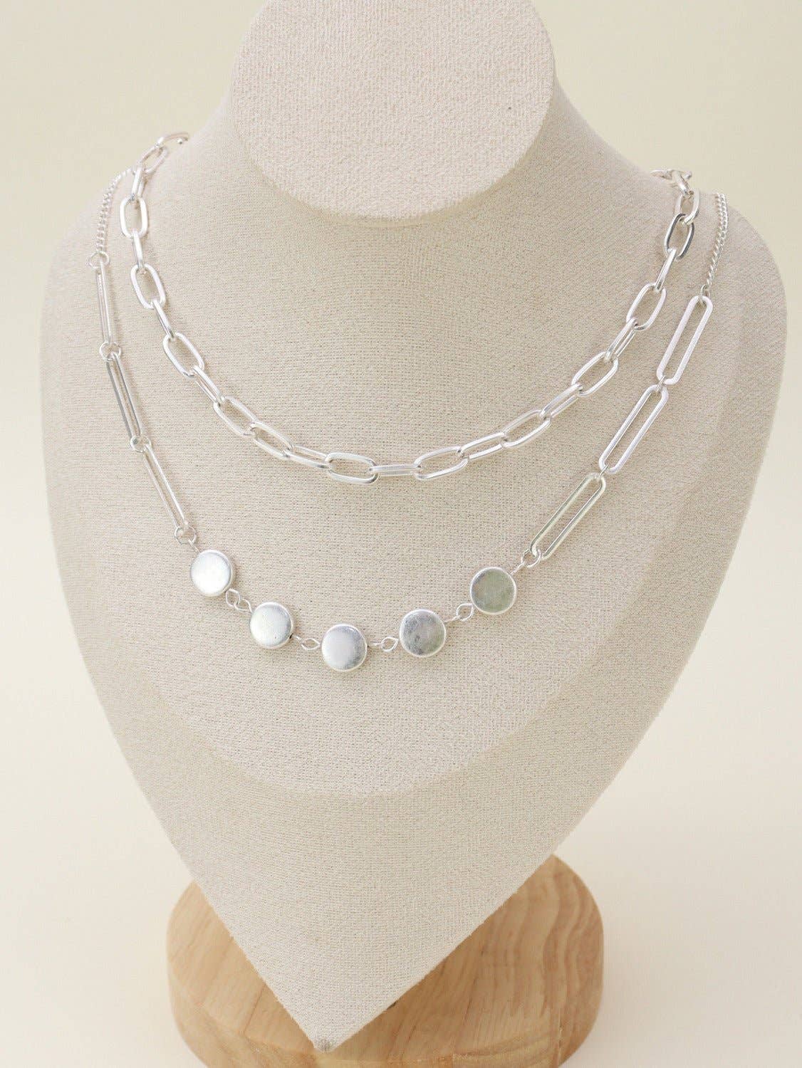 Two Layer Chain Necklace Set displayed on a jewelry stand, showcasing elegant silver chains and round pendants.