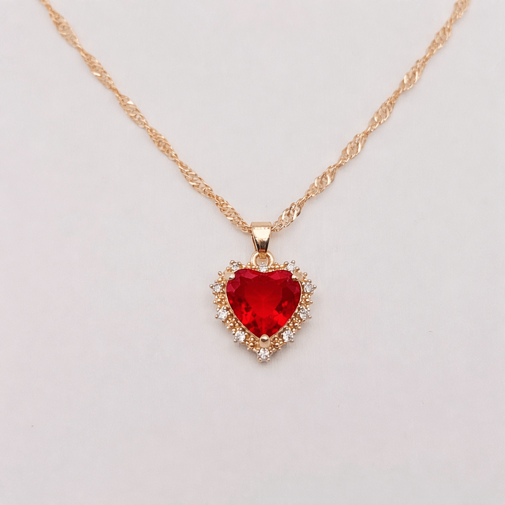 Heart-shaped Pendant Necklace Inlaid Cubic Zirconium with a red gemstone center and gold twist chain.