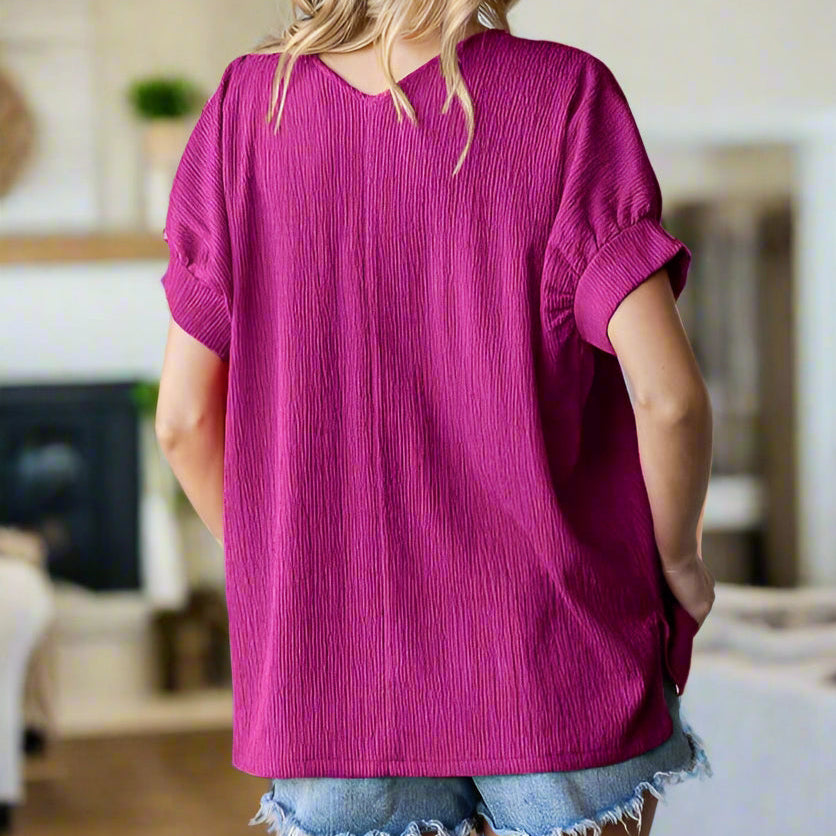 Bright Side Beauty magenta top showcasing a textured design, V neckline, and banded short sleeves for a casual, stylish look.