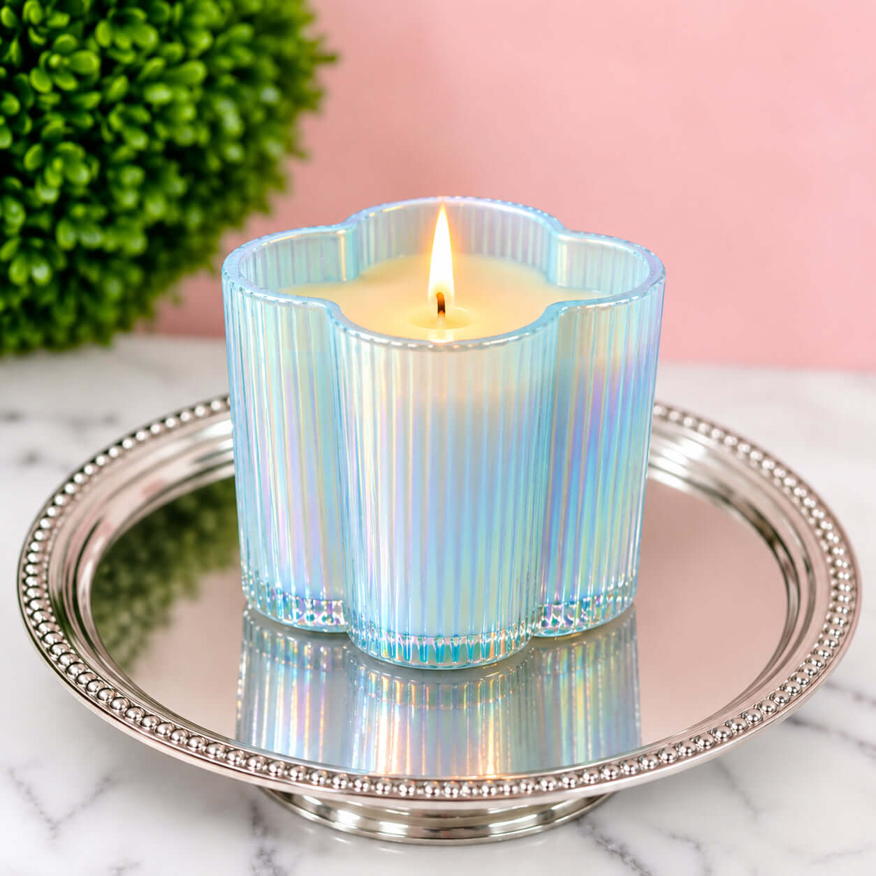 SWEET GRACE BEAUTY BLOOMS CANDLE in iridescent blue flower-shaped glass on silver tray.