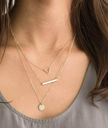 Modern layered necklace set featuring triangle, bar, and circle pendants in gold.