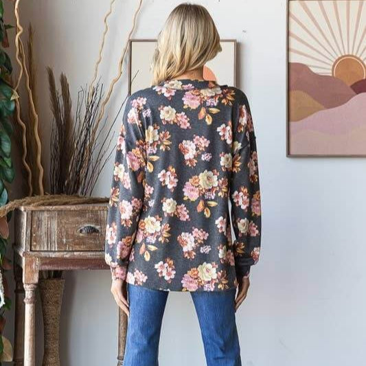 Back view of model wearing ET7683-12 LONG PUFF SLEEVE FLORAL PRINT TOP with jeans in a stylish setting.