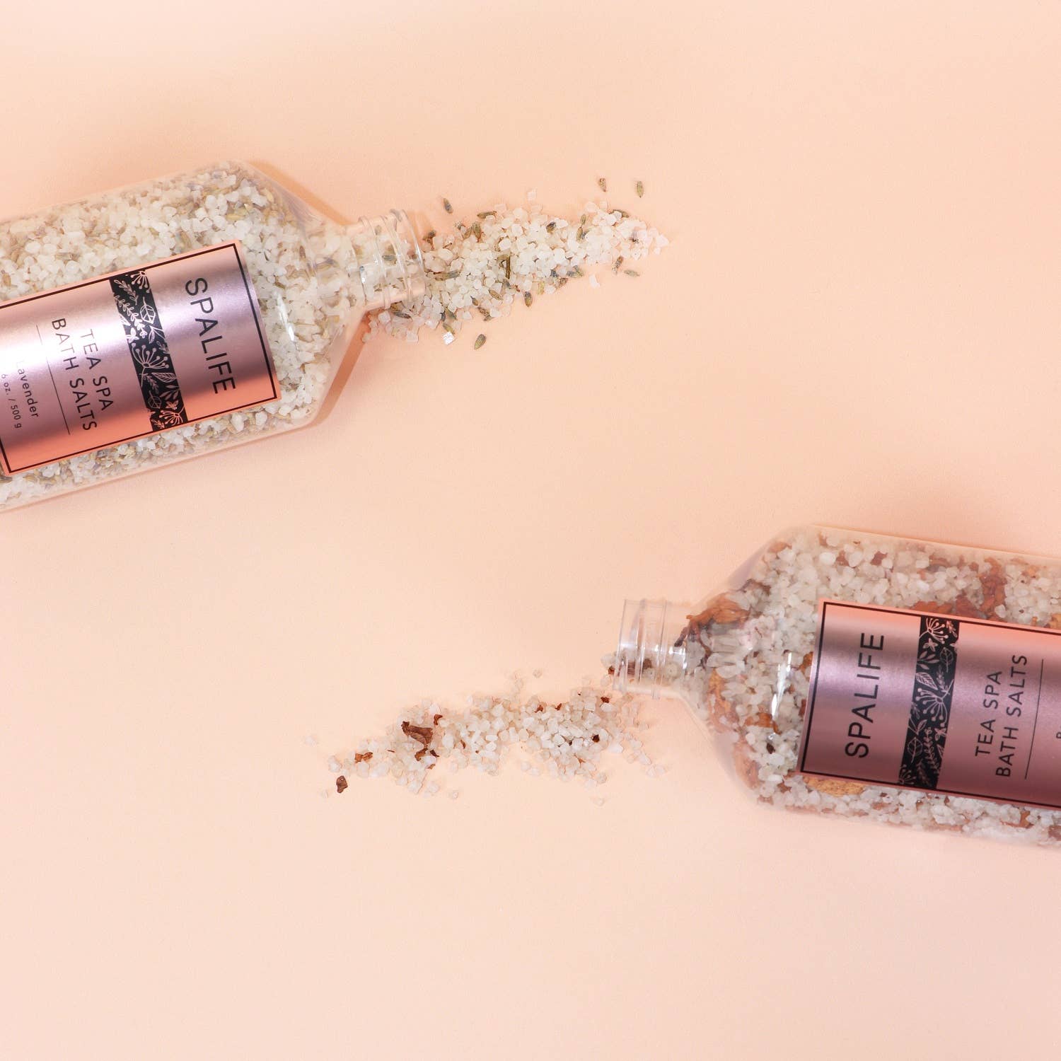 Petal-Infused Effervescent Mineral Bath Salts (Duo Pack) with lavender and rose bath salts spilling from jars.