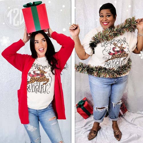Two women wearing Run Run Rudolph Christmas T-shirts, one in a red cardigan, festive atmosphere with holiday decorations.