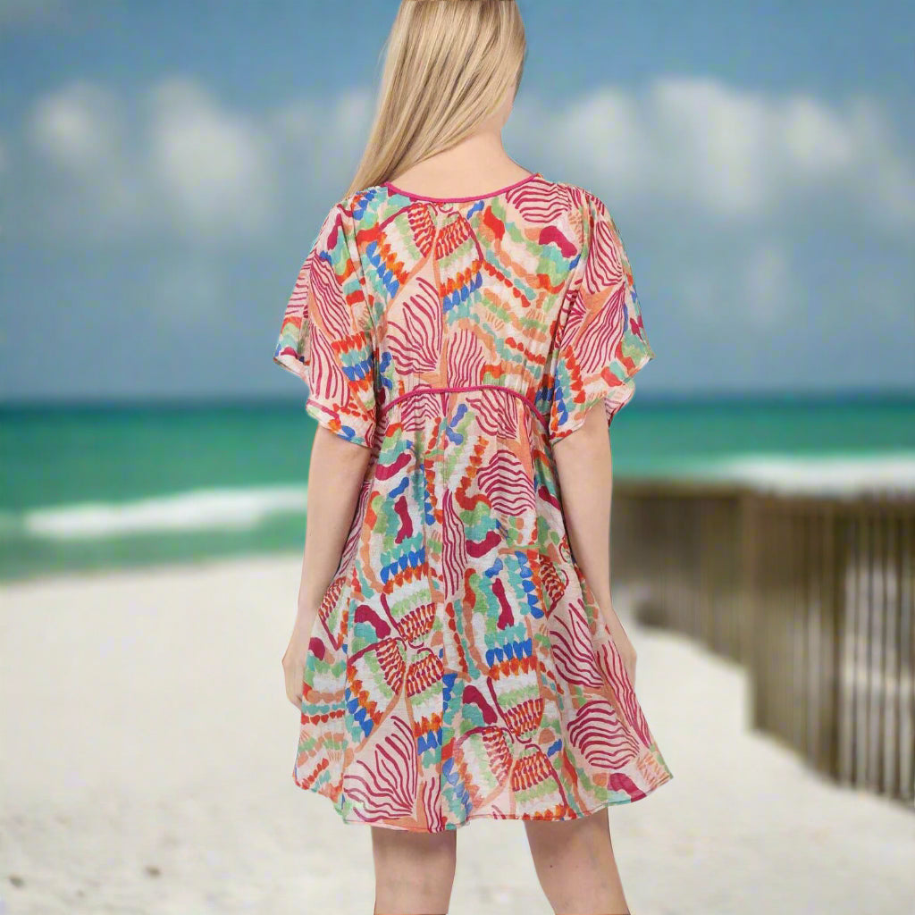 Vibrant multi-color Island Mirage Beach Dress back view on a sunny beach.