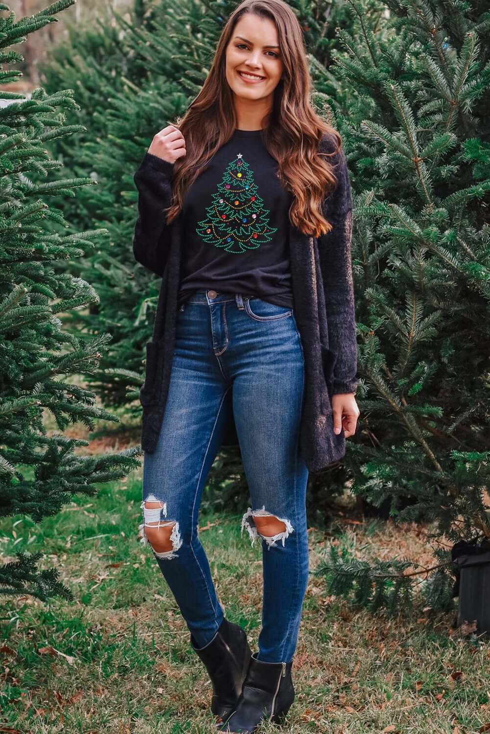 Fashionable woman wearing CHRISTMAS GEMS t-shirt with studded Christmas tree design in outdoor tree lot.