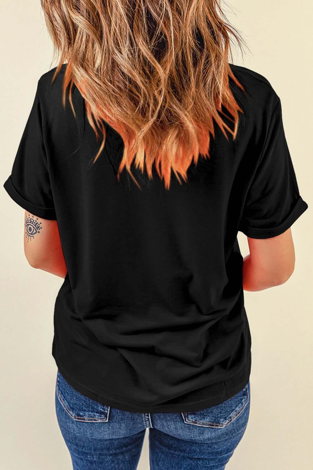 Back view of a woman wearing a black t-shirt, showcasing style versatility and casual fashion.