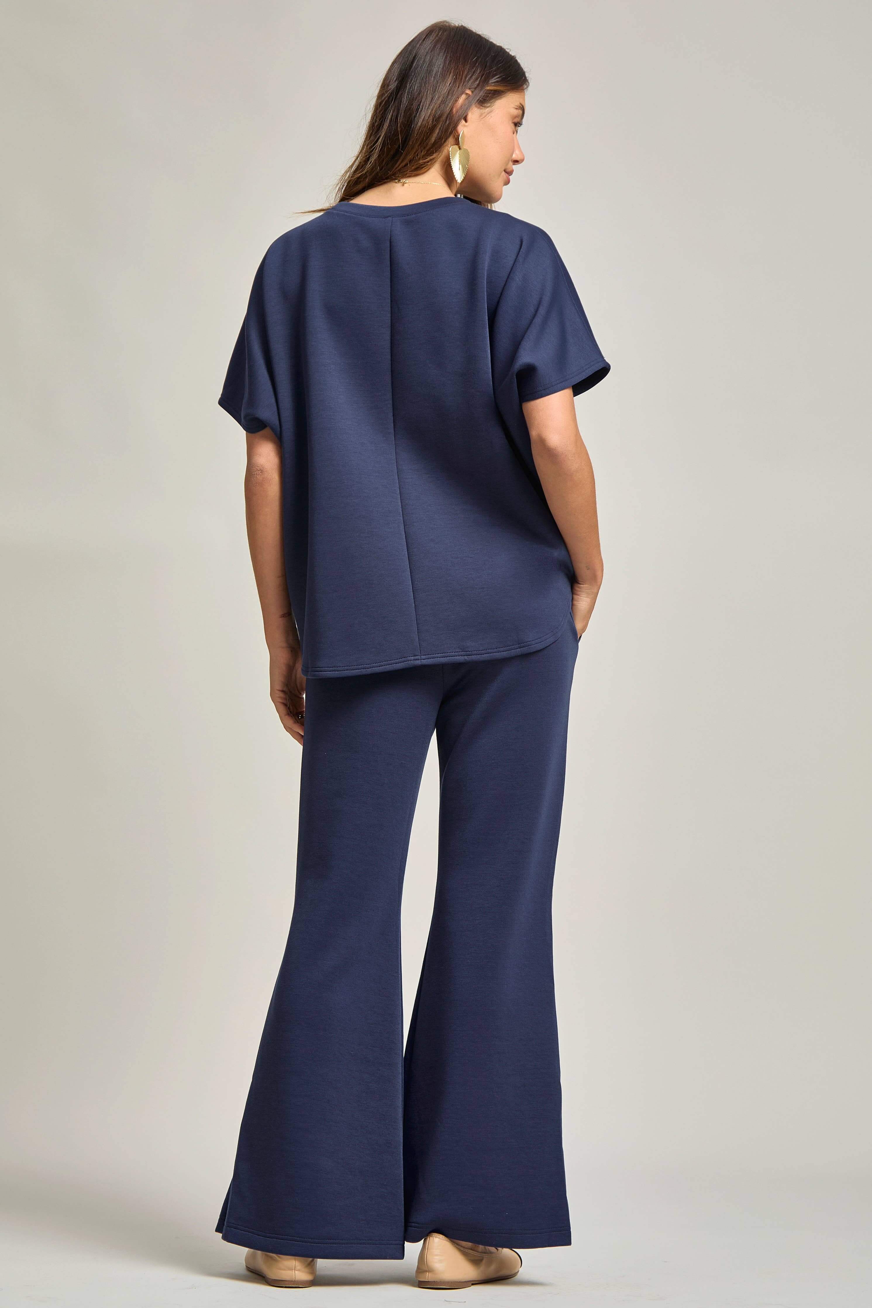 Model wearing a Poncho Top + Bell Bottom Modal Set, showcasing a stylish navy outfit from the back.