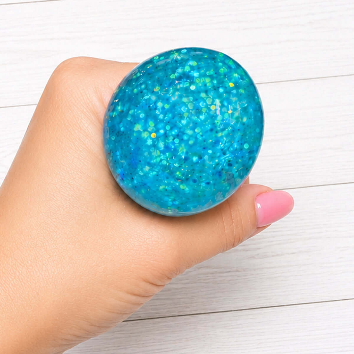 LIL PET FACE GLITTER DUMPLINGS squishy toy held in hand, showcasing vibrant glitter and soft foam texture.