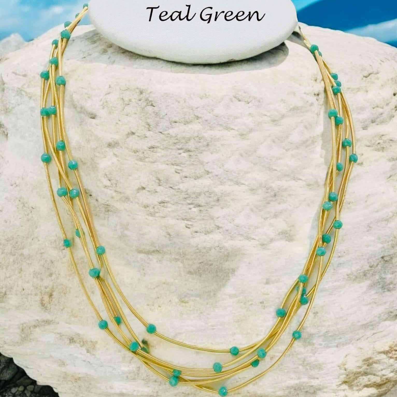 Teal green Pretty Strands Necklace with gold tone multi strands and glass beads, adjustable length by Nine Jewelry.