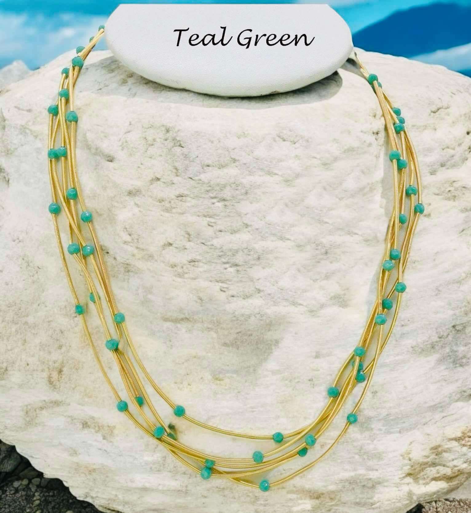 Teal green Pretty Strands Necklace with gold tone multi strands and glass beads, adjustable length by Nine Jewelry.