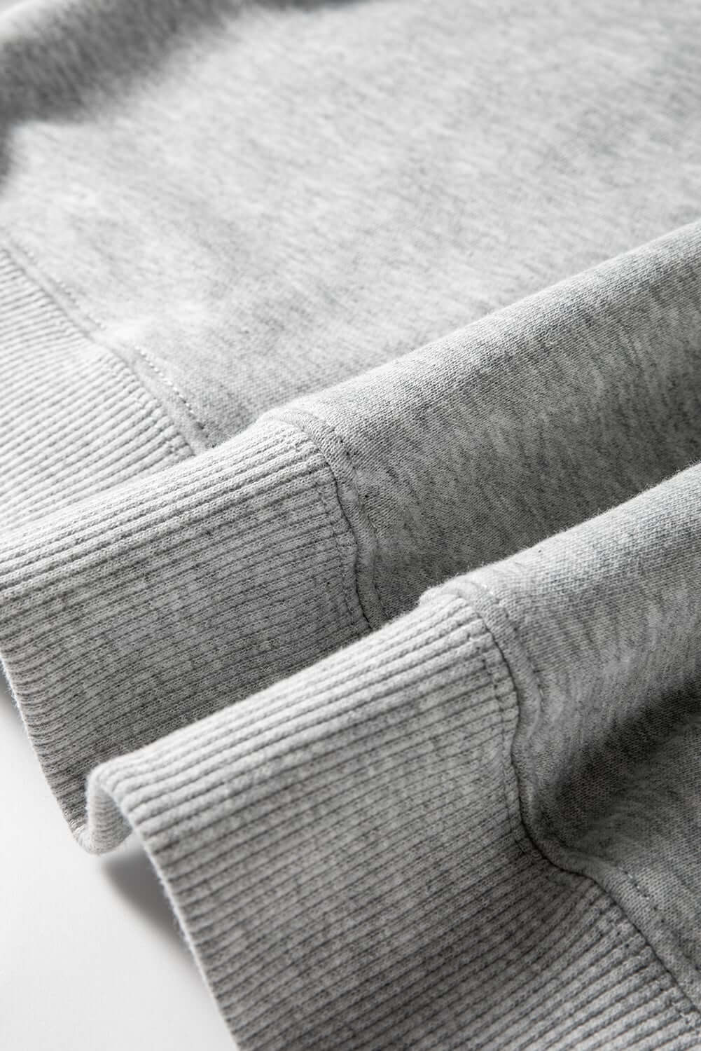 Close-up of gray sweatshirt cuffs showcasing soft fabric and ribbed details, perfect for cozy holiday styling.